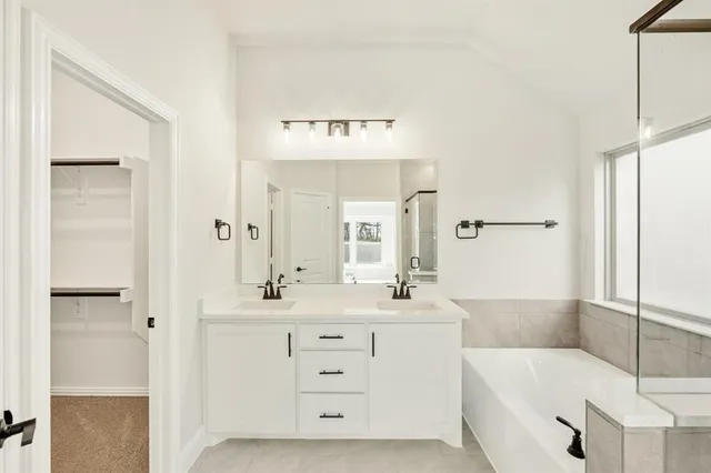 a bathroom with a bathtub sink and mirror