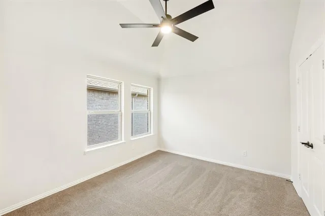an empty room with a window and ceiling fan