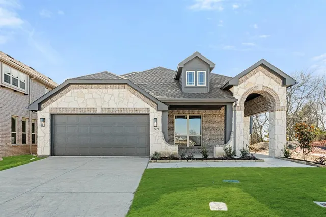 a front view of a house with a garden
