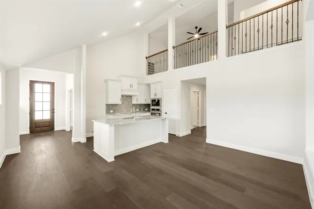 a kitchen with stainless steel appliances kitchen island wooden floors and white walls