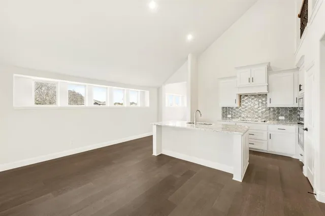 a kitchen with white cabinets and sink