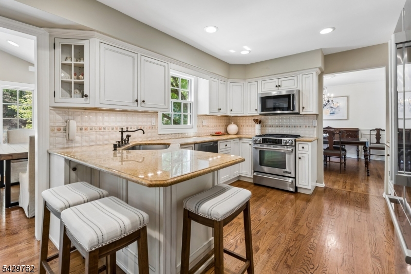 738 Springfield Avenue Summit, NJ 07901 - Photo 12 of 29 a kitchen with stainless steel appliances granite countertop a stove top oven a sink a stove a dining table and chairs