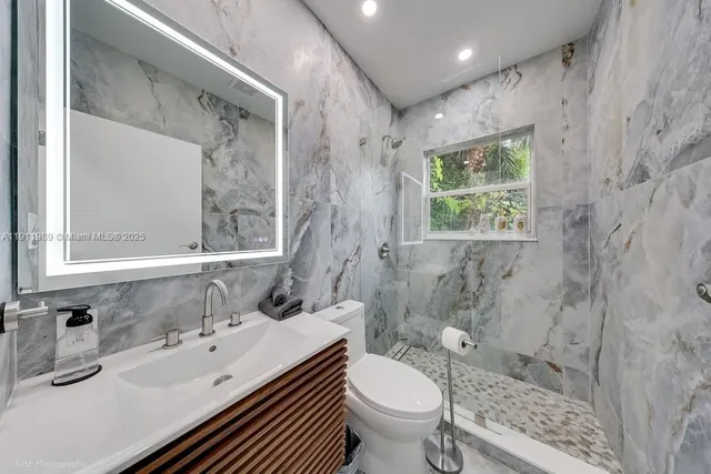 a bathroom with a sink toilet a mirror and shower