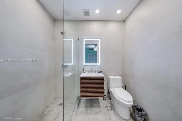 a bathroom with a toilet a sink and mirror