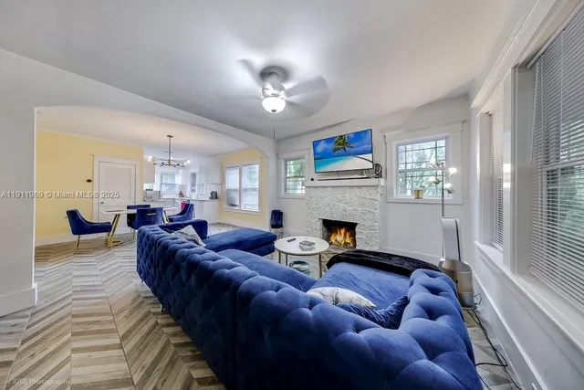 a living room with furniture a fireplace and a large window
