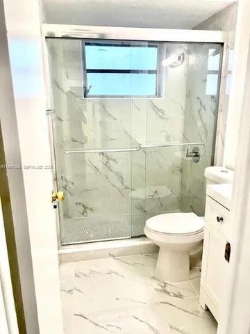 a bathroom with a toilet and a shower