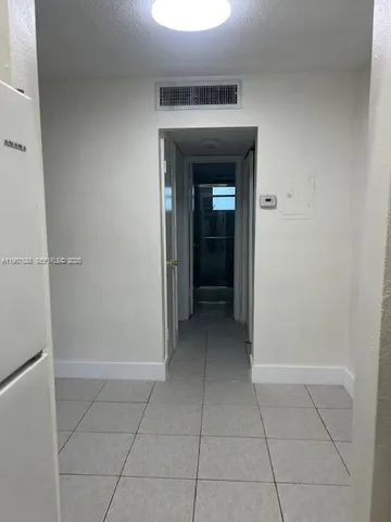 a view of an empty room with cabinet and a window