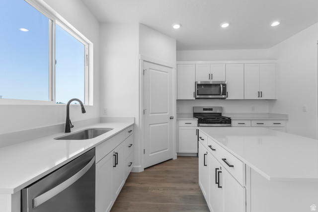 1355 West 2350 South, Unit 11 Perry, UT 84302 - Photo 3 of 39 Kitchen featuring white cabinetry, light countertops, wood-finish flooring, recessed lighting, and a stainless steel appliance package including a gas range, microwave, and dishwasher