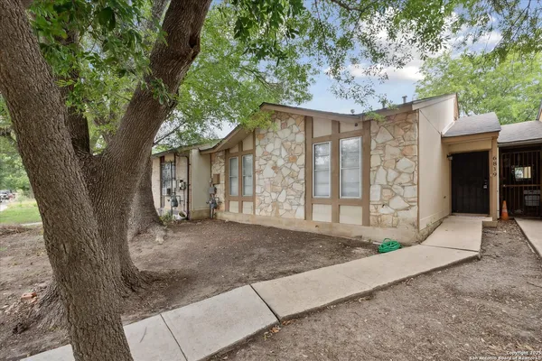 a view of a house with a tree in front of it