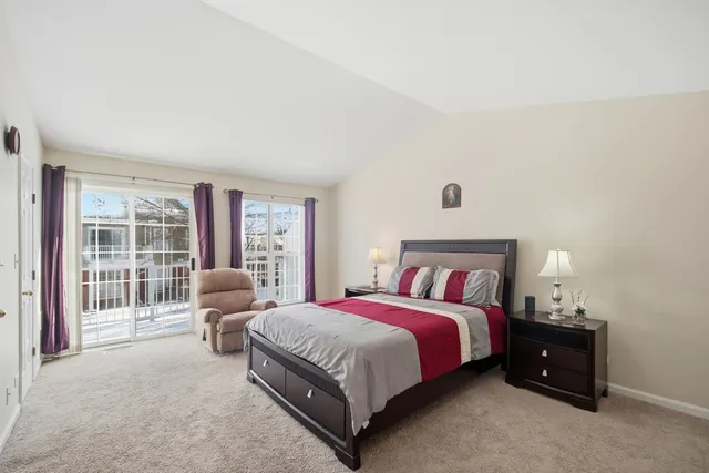 a spacious bedroom with a bed and glass window
