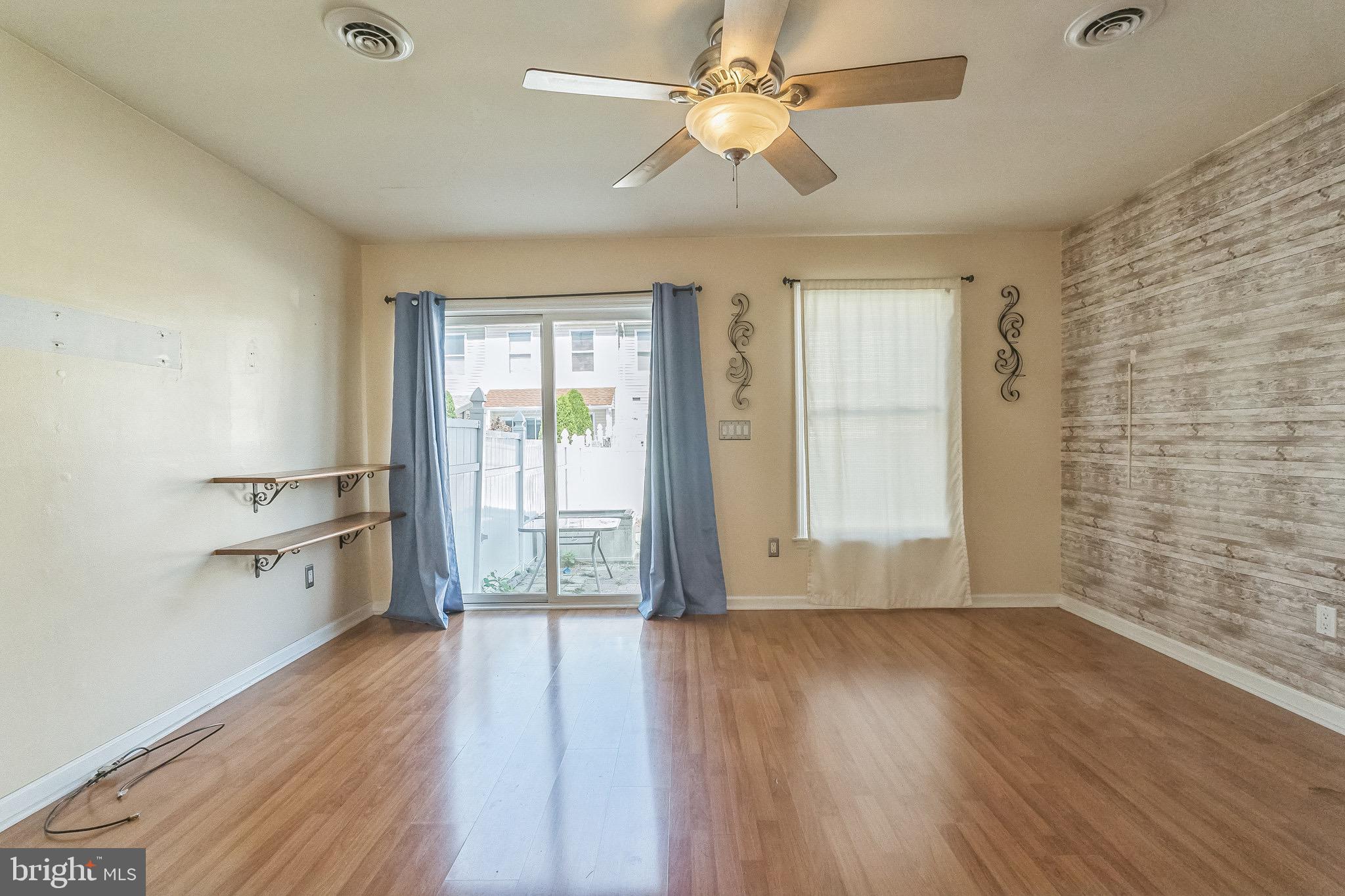 3566 Edgemont Street Philadelphia, PA 19134 - Photo 11 of 25 an empty room with wooden floor chandelier fan and windows