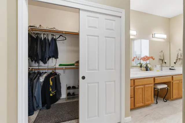 a view of a white house with a yard and potted plants