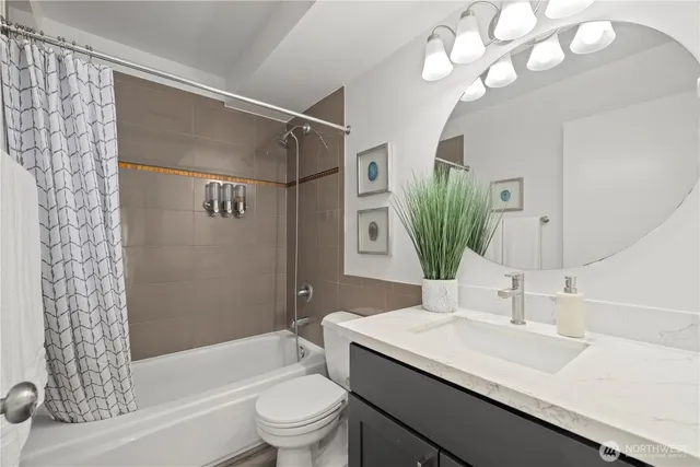 a bathroom with a sink a toilet a mirror a vanity and shower