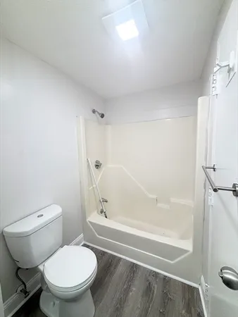 a white toilet sitting next to a bath tub