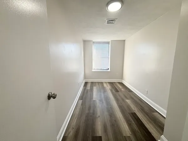 a view of a room with wooden floor and white walls