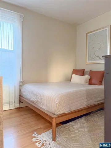 a bedroom with a bed and painting on the wall