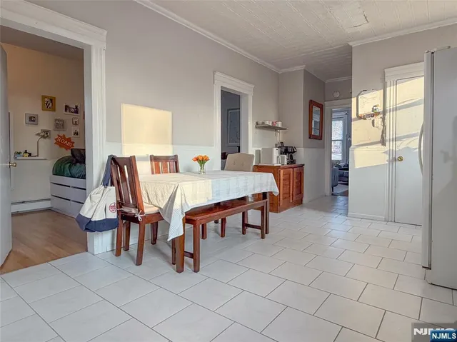 a view of dining room and livingroom with furniture wooden floor a rug a painting and a chandelier