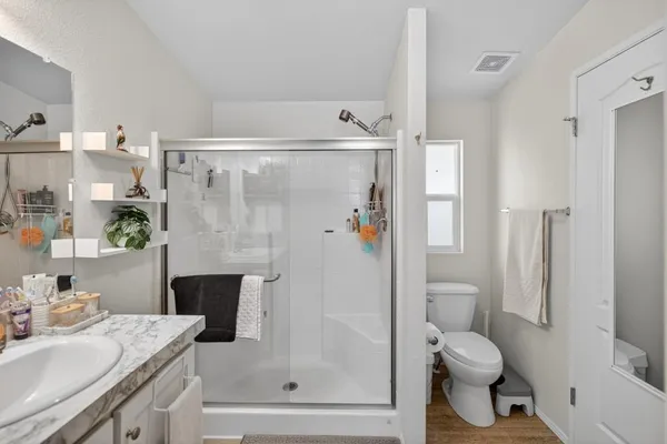 a bathroom with a granite countertop sink toilet and shower