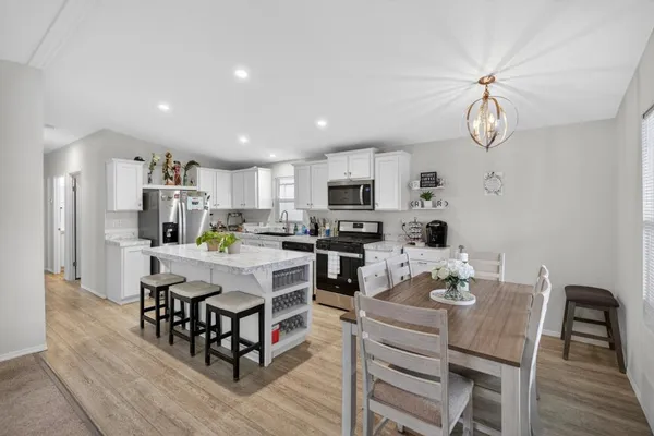 a kitchen with a dining table chairs and stainless steel appliances