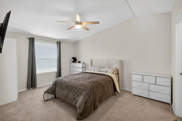 a bedroom with a bed and a ceiling fan
