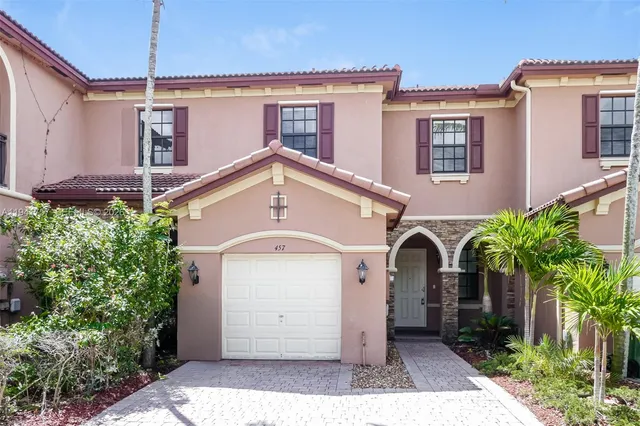 a front view of a house with plants