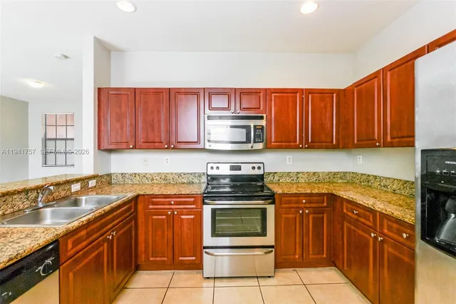 a kitchen with stainless steel appliances granite countertop a stove sink and cabinets