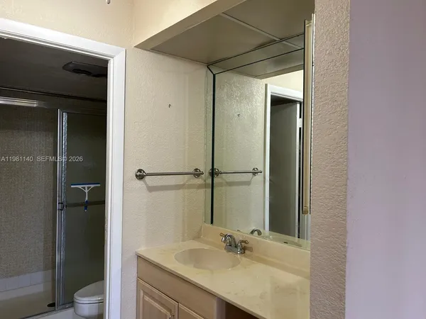 a bathroom with a sink mirror toilet and shower