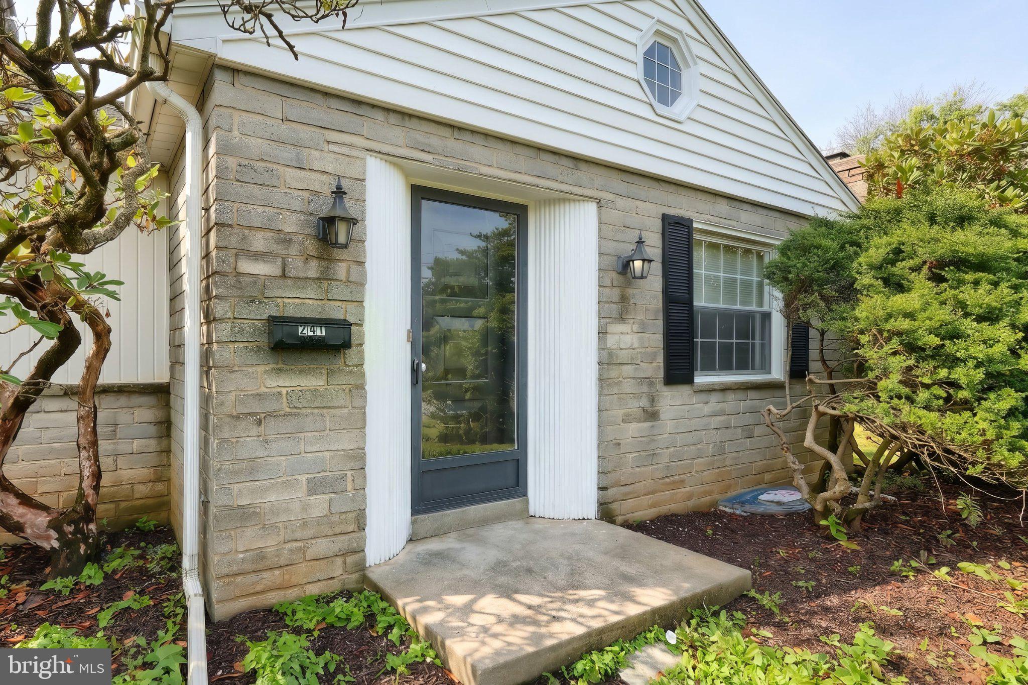 Charming entryway with lush greenery.