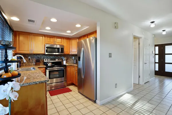 a kitchen with granite countertop wood cabinets and stainless steel appliances