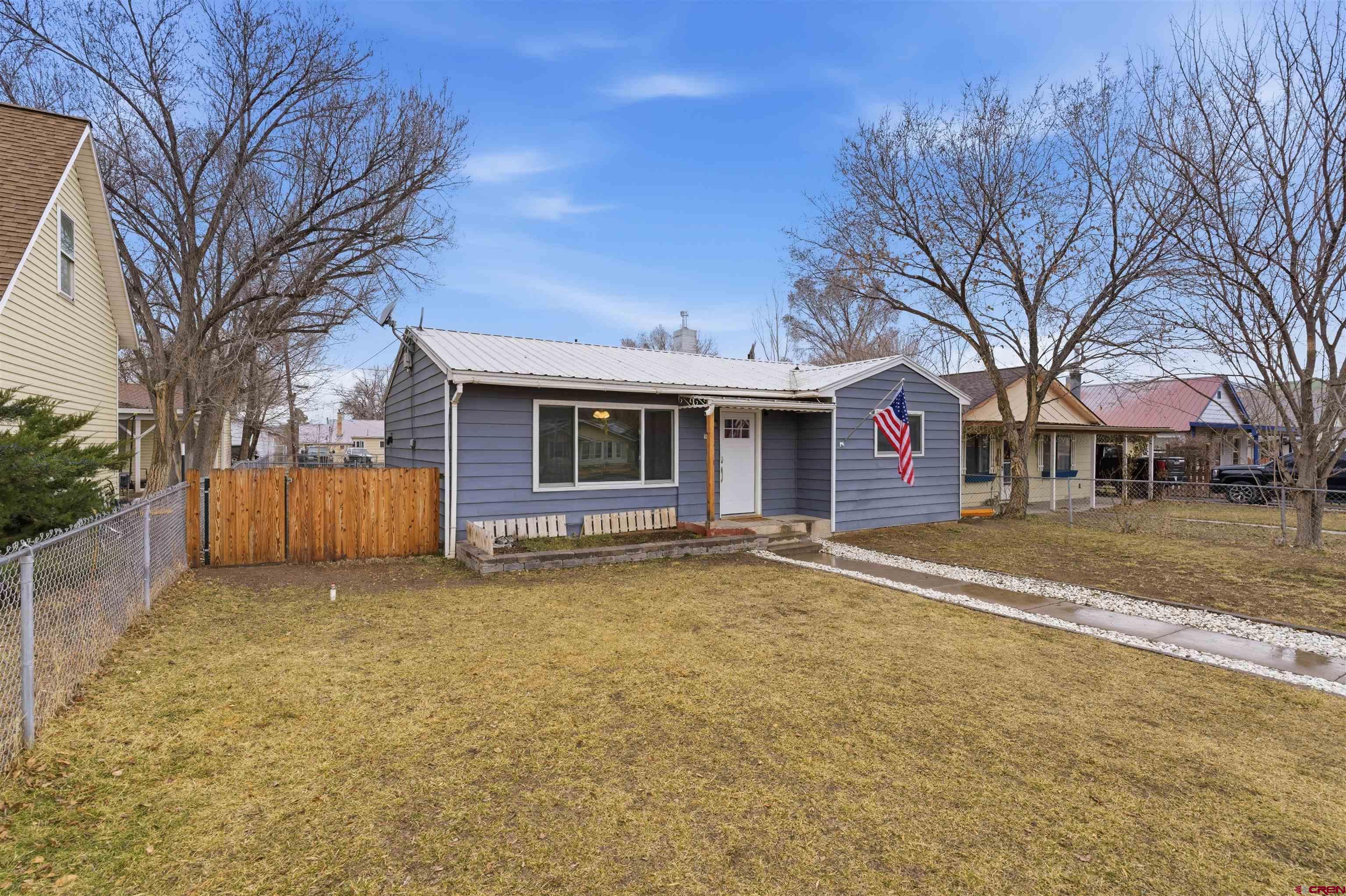 1029 Howard Street Delta, CO 81416 - Photo 2 of 17 a view of a house with a large tree and a yard