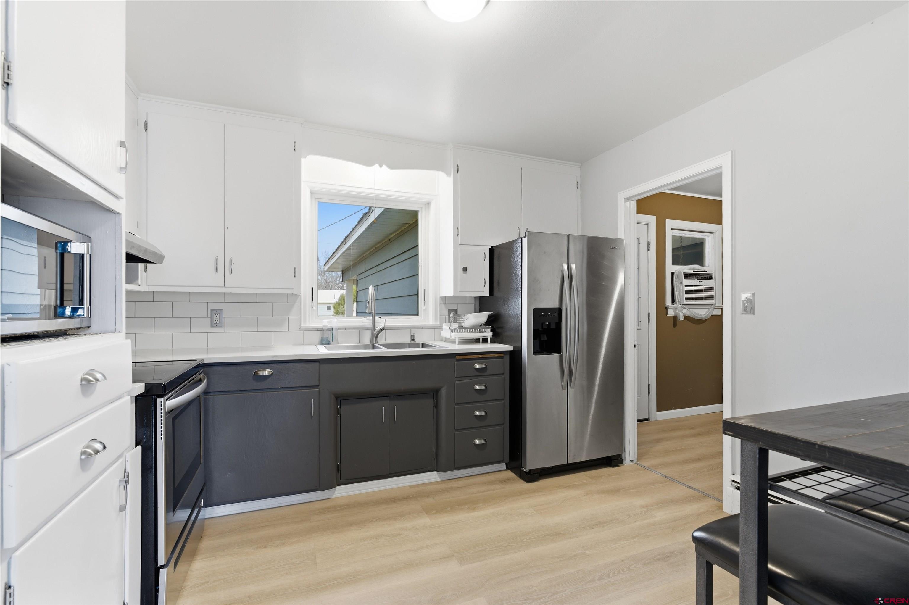 1029 Howard Street Delta, CO 81416 - Photo 5 of 17 a kitchen with stainless steel appliances granite countertop a refrigerator sink and stove