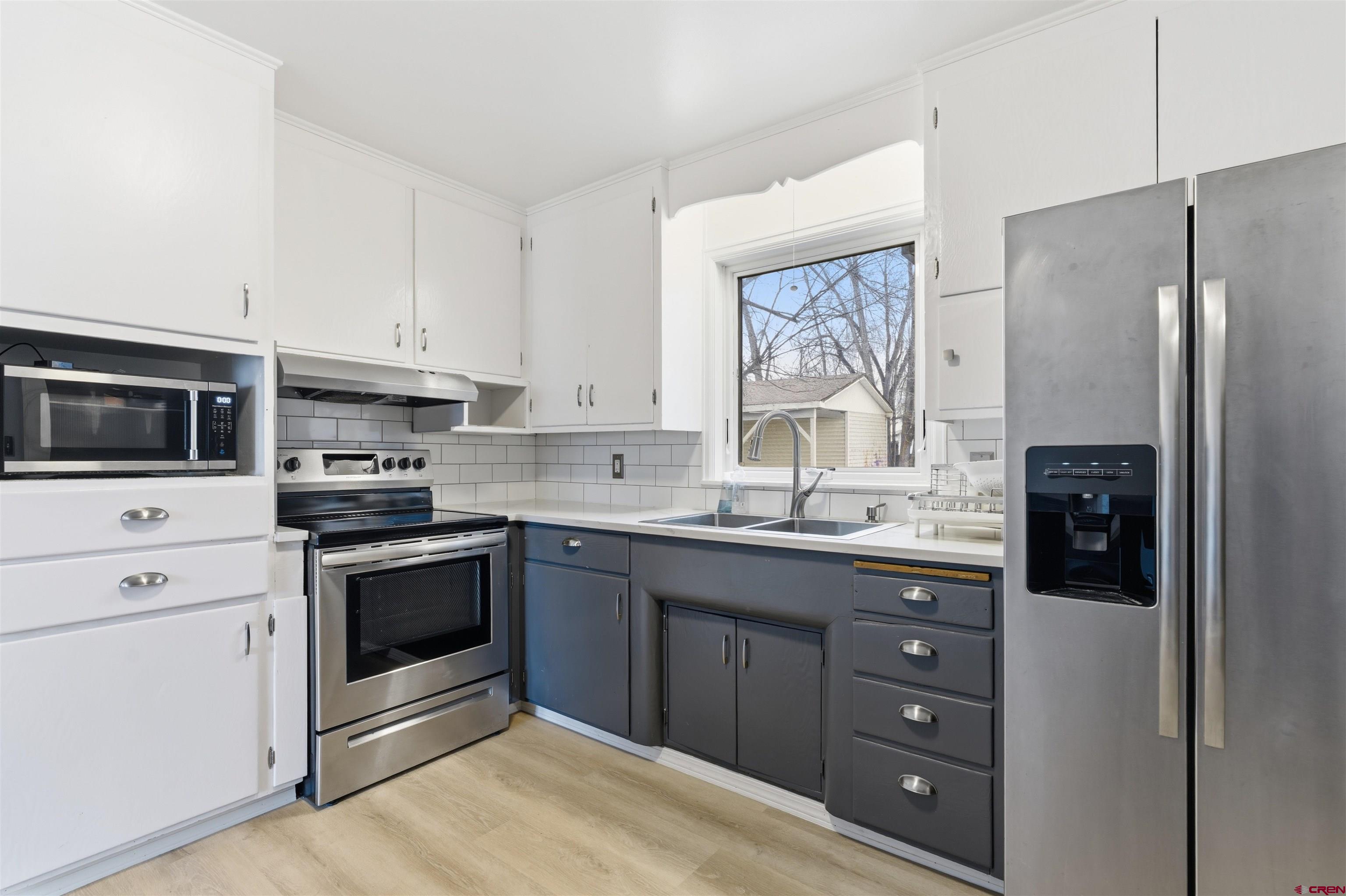1029 Howard Street Delta, CO 81416 - Photo 6 of 17 a kitchen with stainless steel appliances granite countertop a refrigerator and a stove top oven