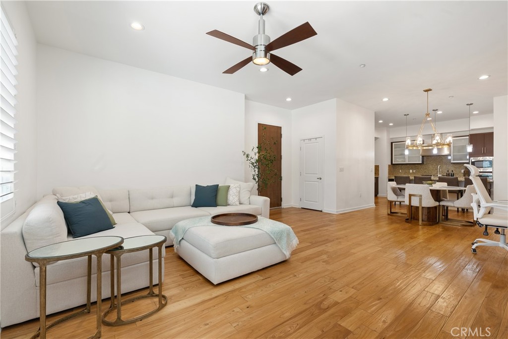 21 Gramercy, Unit 102 Irvine, CA 92612 - Photo 5 of 30 Modern living room featuring contemporary finishes, sleek ceiling fan, and an airy open layout.