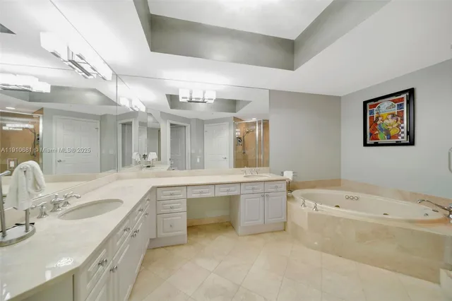 a large bathroom with a tub a double vanity sink a toilet a mirror and