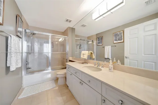 a bathroom with a double vanity sink toilet mirror and shower