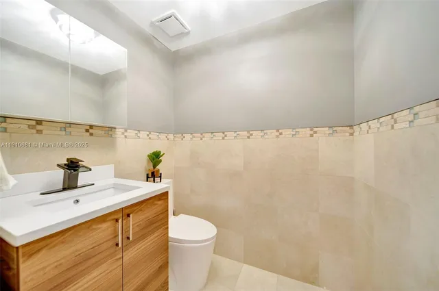 a bathroom with a sink vanity granite and toilet