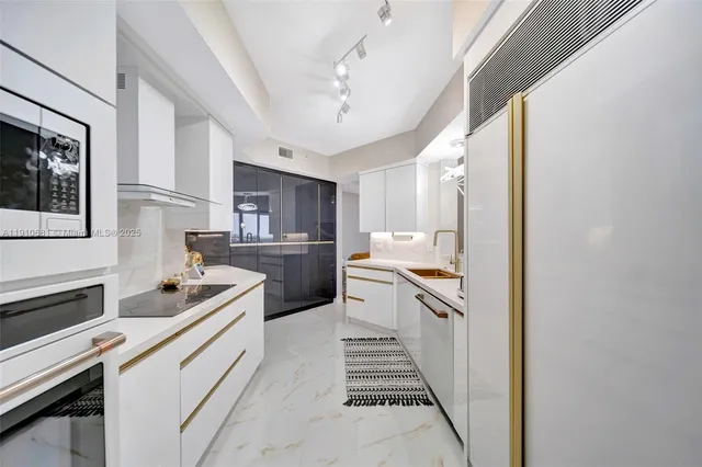 a kitchen with white cabinets and appliances