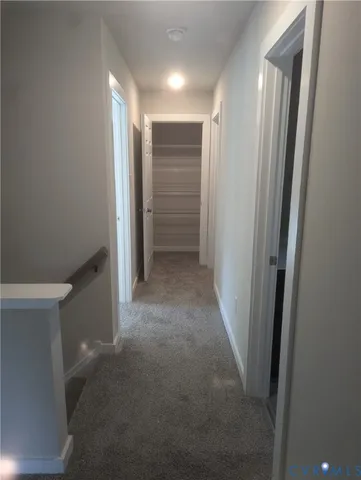 a view of hallway with closet and a bathroom