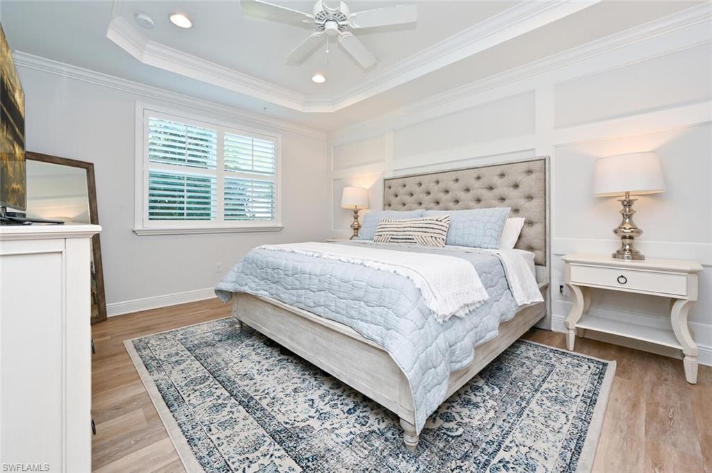 6934 Avalon Circle, Unit 401 Naples, FL 34112 - Photo 3 of 13 a bedroom with a large bed and a chandelier