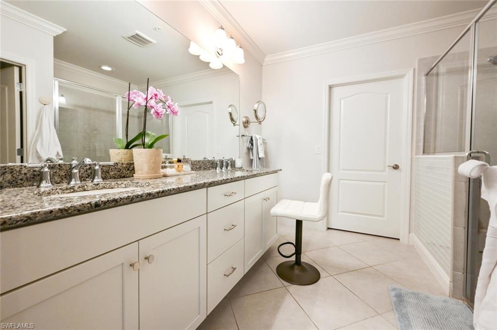 6934 Avalon Circle, Unit 401 Naples, FL 34112 - Photo 4 of 13 a bathroom with a sink and a mirror