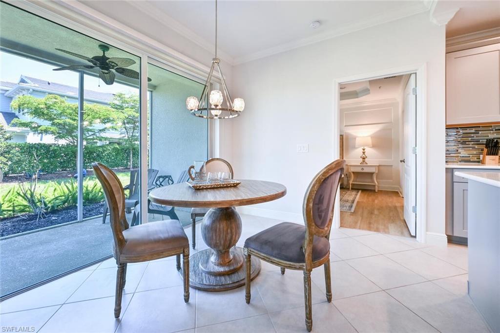 6934 Avalon Circle, Unit 401 Naples, FL 34112 - Photo 5 of 13 a dining room with furniture a chandelier and wooden floor
