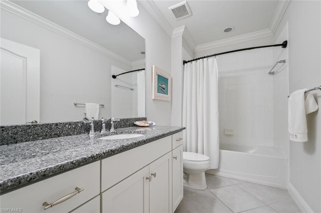 6934 Avalon Circle, Unit 401 Naples, FL 34112 - Photo 9 of 13 a bathroom with a granite countertop sink a toilet and shower