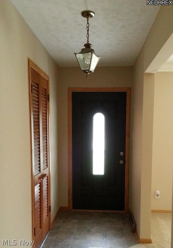 1998 Wyndham Road Akron, OH 44313 - Photo 3 of 25 Upon entering, spacious foyer greets you. New laminate flooring and paint. A coat closet to the left and living room to the right. Entire inside of the home has been painted, new carpets and flooring, lighting in certain rooms, and a deep cleaning. Hardwood is beneath the carpeting in most rooms (except kitchen and baths).