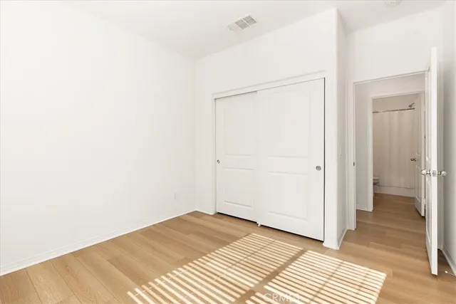 a view of a room with wooden floor and a bathroom