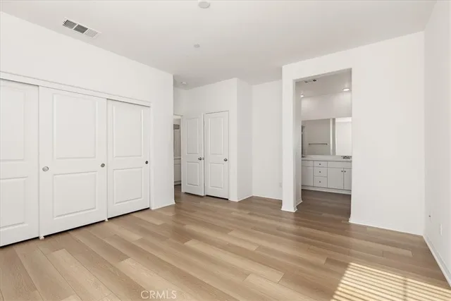 an empty room with wooden floor and white walls
