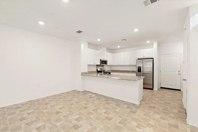 a large white kitchen with stainless steel appliances