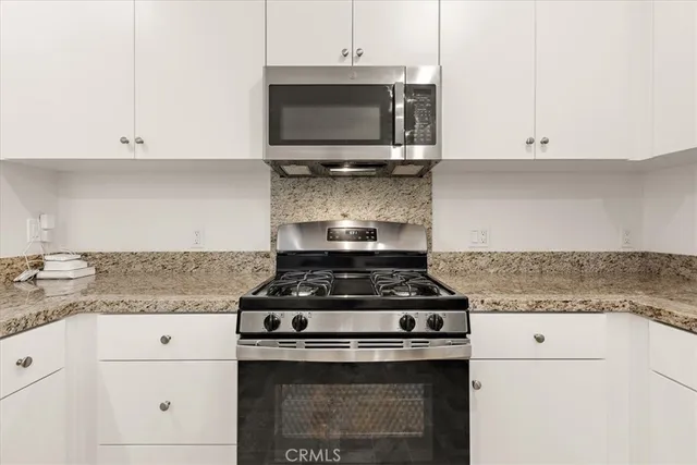 a stove top oven sitting inside of a kitchen