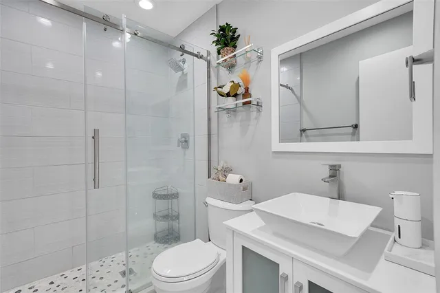 a bathroom with a sink a toilet and shower