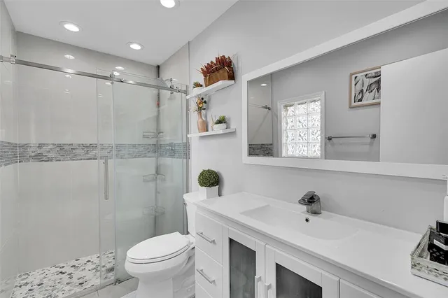 a bathroom with a sink mirror vanity and toilet