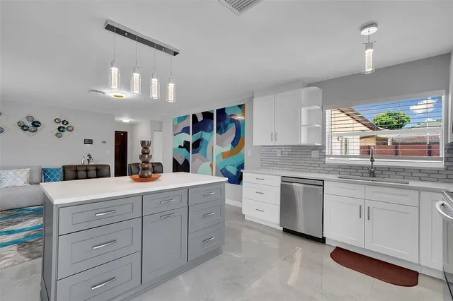 a kitchen with kitchen island granite countertop a sink and cabinets